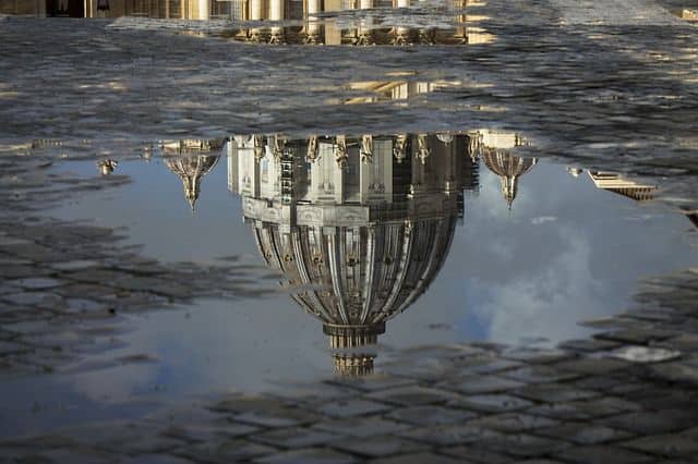 Zwei Wege der vatikanischen Sekte zu entfliehen: Die Kuppel des Petersdom im Vatikan, spiegelt sich auf dem Kopf stehend im Wasser